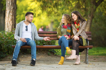 Three young people on a bench in a park