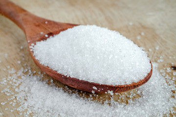 Fototapeta na wymiar White sugar on wooden spoon.Food and health concepts