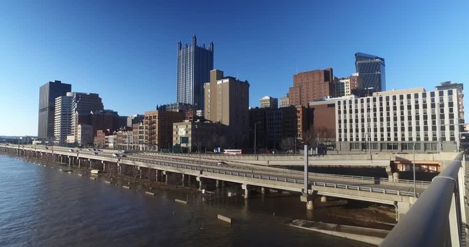 A dolly-up reveal of the Pittsburgh city skyline and Monongahela River on a late winter sunny day.  	