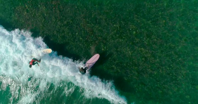 Aerial drone footage of textured pattern formed by white sea foam. Lockdown shot of huge ocean waves crashing on shore. As the waves calm the appearance changes. View from the top. 4K slow motion.