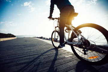 Fototapeta na wymiar cyclist riding bike in the sunrise coast path