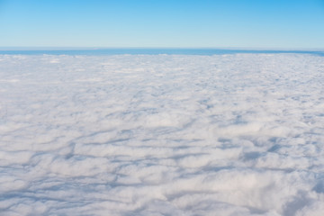 Fototapeta na wymiar White clouds with blue sky and horizon in beautiful day, above view from air plane