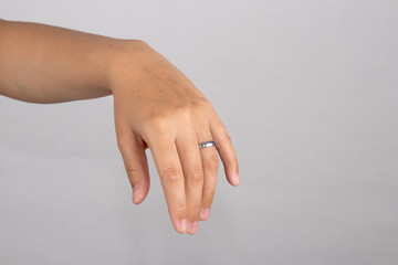 Close-up a ring on ring finger to show honesty of love isolated on white background.