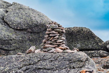 A pile of stones for tourist navigation. Mountain view, walking tour