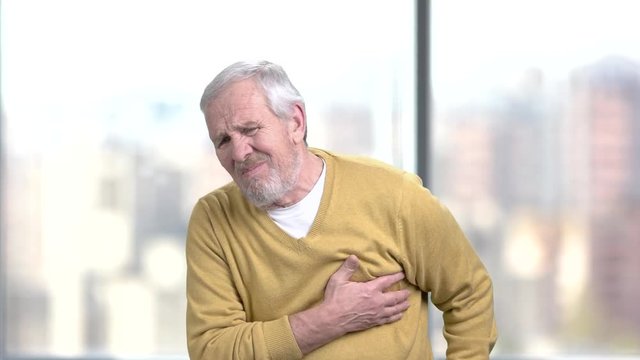 Senior man having heart attack. Elderly male taking medicine from heart ache. How to prevent heart attack.