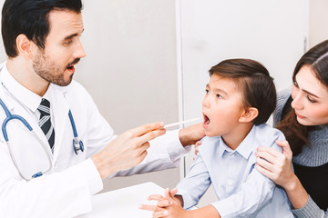 Doctor having throat examined checking little boy in hospital.healthcare and medicine
