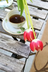Tulip flowers with cup of coffee on a small table