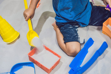 Boy playing with sand in preschool. The development of fine motor concept. Creativity Game concept