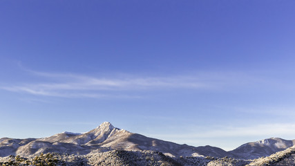 Fototapeta na wymiar Solid blue sky landscape on a snowy peak mountains