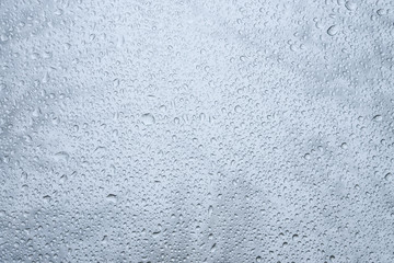 Drops on the glass window. Dramatic blurry background of street rain