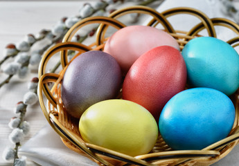 Traditional Easter  painted eggs prepared for the celebration of Easter are on the wooden table with willow branch