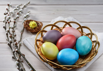 Traditional Easter  painted eggs prepared for the celebration of Easter are on the wooden table with willow branch