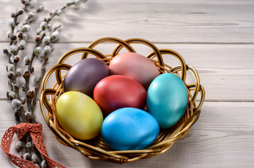 Traditional Easter  painted eggs prepared for the celebration of Easter are on the wooden table with willow branch