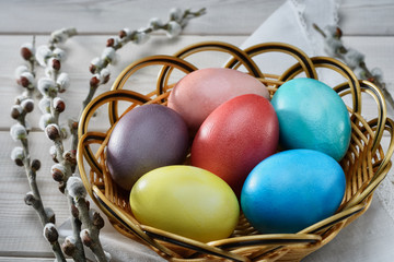 Traditional Easter  painted eggs prepared for the celebration of Easter are on the wooden table with willow branch