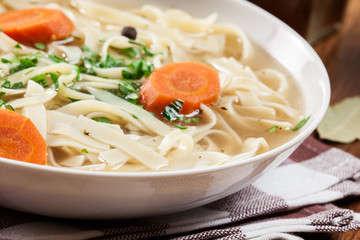 Tasty meat broth with noodles, carror and parsley