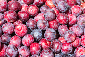 resh ripe plums placed on table in market.