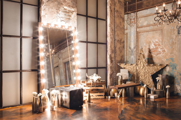 Loft interior with mirror, candles, brick wall, large window, living room, coffee table in modern design