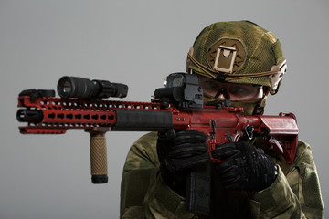 Picture of aiming military man in helmet with gun