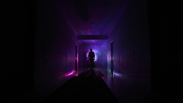 Creepy silhouette in the dark abandoned building. Horror about maniac concept or Dark corridor with cabinet doors and lights with silhouette of spooky horror person standing with different poses.