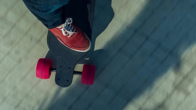 a man's feet on an electric skateboard as it moves along the ground