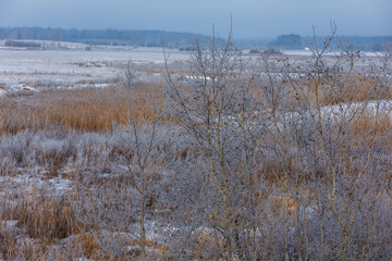 Winter morning, snowy surroundings, cold, frosty. Little river with ice. In some places, the river is not frozen. Winter landscape in the countryside with a small river.