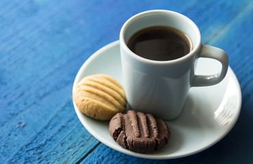 Morning coffee with cookies on blue wooden background