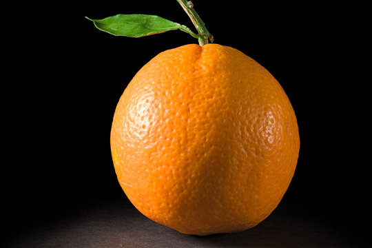 One ripe oranges on black background