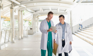 medical doctor professional team talked consult. Two young doctor Caucasian and Asian standing in...