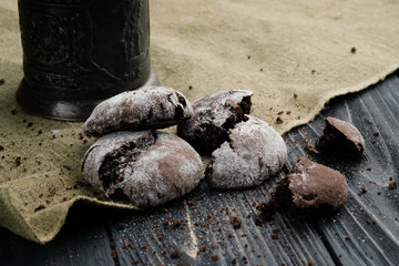 Homemade chocolate cookies on wooden table and textile background
