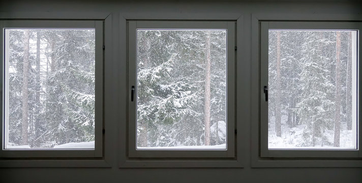Three windows with a cold snow storm outside.