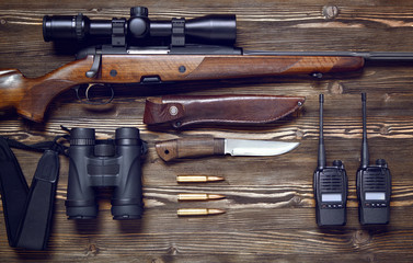 Hunting rifle and ammunition on a wooden background.