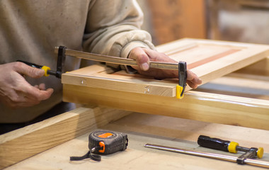 Manual manufacturing of furniture from a natural tree in a workshop.