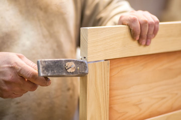 Manual manufacturing of furniture from a natural tree in a workshop.