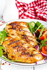 Grilled chicken breast. Fried chicken fillet and fresh vegetable salad of tomatoes, cucumbers and arugula leaves. Chicken meat salad. Healthy food. White background