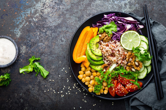 Buddha Bowl Dish With Brown Rice, Avocado, Pepper, Tomato, Cucumber, Red Cabbage, Chickpea, Fresh Lettuce Salad And Walnuts. Healthy Vegetarian Eating, Super Food. Top View