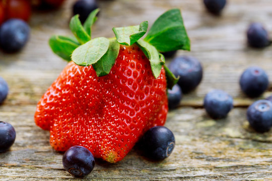 ingredients for a healthy Grape Strawberry Blueberries berries, fruit, and wooden background, top view, horizontal