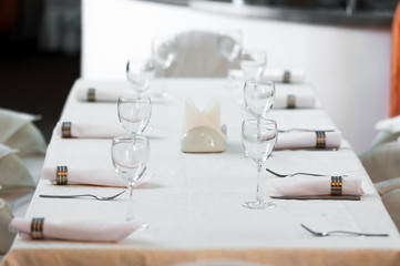 Banquet decorated table, with cutlery. Wedding decor in the banquet hall.Serving of a festive table, plate, napkin, knife, fork. Table setting decoration. Romantic Dinner or other events.