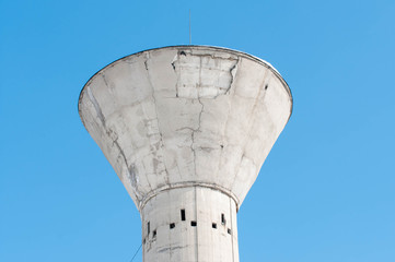 Old concrete tower close up shot on beautiful blue sky background.
