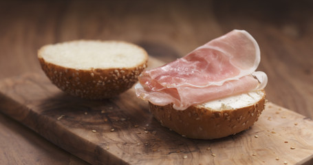 sandwich with prosciutto and cream cheese on wood board