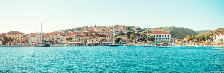 Fototapeta na wymiar POSTIRA, CROATIA - JULY 14, 2017: Beautiful harbor of a small town Postira with several yachts moored there - Croatia, island Brac
