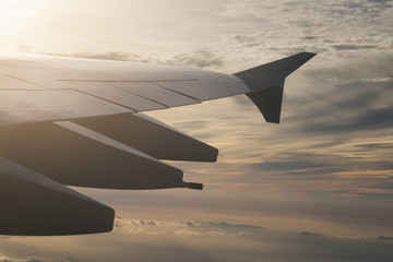 Fototapeta na wymiar view of airplane wing during flight in sunset