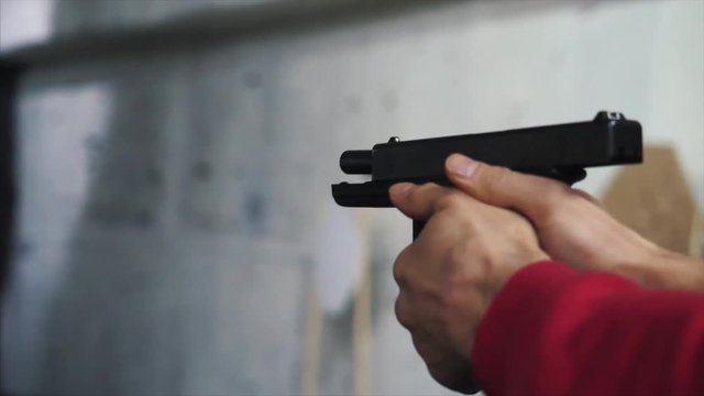 Gun is shot close-up. Pistol in hand close-up. Pistol being shot 1 times. Man shoots a black gun
