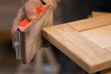 Manual manufacturing of furniture from a natural tree in a workshop.