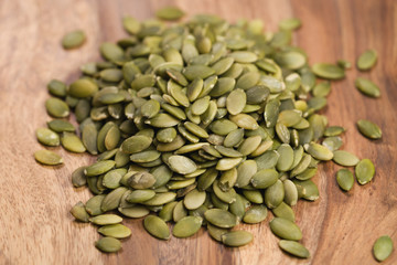 green pumkin seeds on wooden table