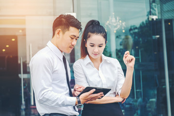 Obraz premium Asian Business couple meeting Using digital tablet outdoor after work