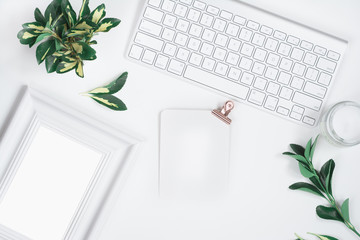 White background with frame mockup, yellow-green leaves, scented candle and keyboard