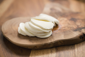 sliced mozzarella cheese on wooden board