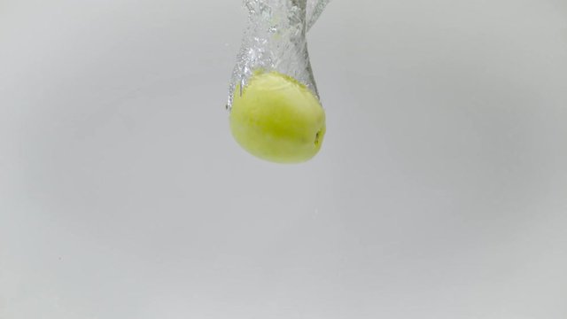 Underwater shot of an apple falling into water, Ultra Slow Motion
