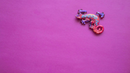 chameleon toy on pink background, copy space