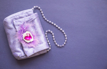 women's purple handbag on a purple background, copy space